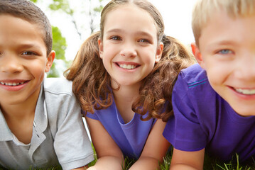 Children, grass and relax together in portrait, natural development and happy bonding with growth. Kids, diversity and outdoor for camp school or social learning, friends and youth community support