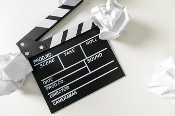 Director's board and crumpled paper on a white background. Thinking about how to create a story.