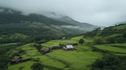 Obraz premium Misty Green Valley With Small Houses