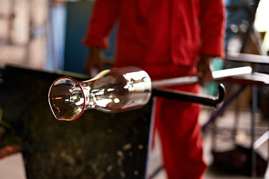 Hands, worker and vase in glass factory for manufacturing, production process and industry. Glassware, craft and man with tools to shape for art, recycling and equipment with product in workshop - Powered by Adobe