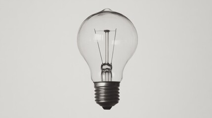 A clear glass light bulb suspended against a minimalistic white background, showcasing its design