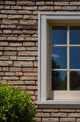 Fototapeta premium Modern Brick House Exterior with Panoramic Window and Lush Greenery