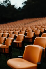 Fototapeta premium Rows of Orange Plastic Chairs in an Outdoor Amphitheater