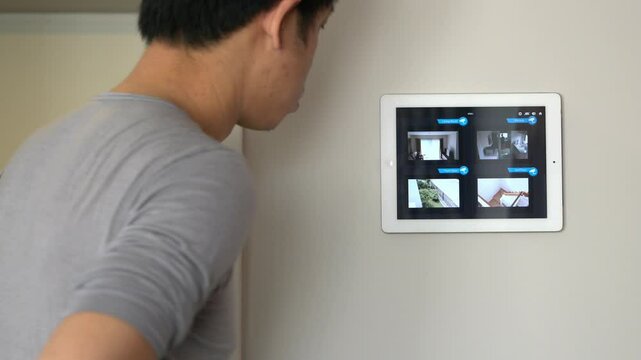 A person monitors home security cameras on a tablet. The image showcases modern technology, emphasizing the convenience of smart home systems in enhancing security and surveillance.