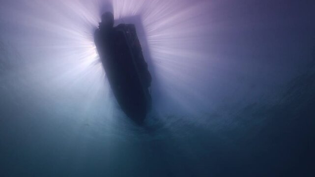 contraluz desde el fondo del mar hacia un bote de buzos 