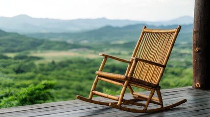 A serene rocking chair made of bamboo sits on a porch, overlooking a lush green landscape with distant mountains.