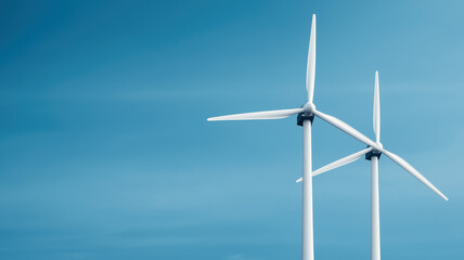 Wind turbines generating clean energy against blue sky backdrop