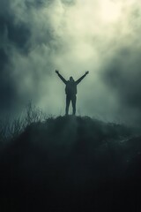 A silhouetted figure stands triumphantly atop a hill, arms raised against a misty, atmospheric backdrop, symbolizing success and freedom. Copy space for texting