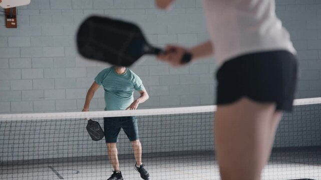 Indian man pickleball smash in a gym