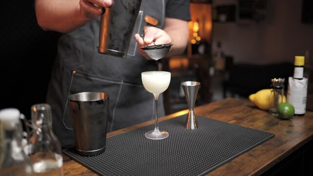 Bartender crafting classic daiquiri cocktail. Perfect for bar promotional videos or mixology classes.