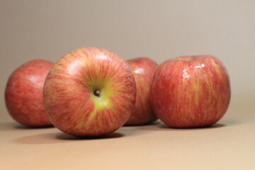 apples on a beige background. It's a sweet, crunchy apple that's shiny and fresh. This is a close-up photo.