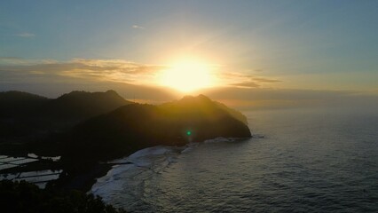 Bird eye View sunrise at the top of of the coastline with hills and trees, cliffs, coral reefs and...