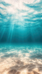 Obraz premium Crystal clear underwater view of ocean with sunlight filtering through water, creating serene and tranquil atmosphere. sandy ocean floor is visible, enhancing beauty of scene
