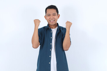 Adult Asian Man Expresses Excitement and Joy Enthusiastically with Fists Raised Triumphantly