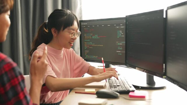 Slow motion back end software developer engineer for computer programming working together on debugging writing computing code, solving complex algorithms display on monitor in office. Burgeoning