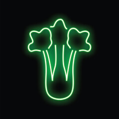 Green neon sign illuminating a bunch of fresh celery on a black background