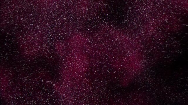 Close-up view of a red splatter, resembling spilled paint or liquid, on a dark surface. The exact substance remains unknown without further information
