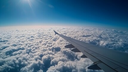 Fototapeta premium Airplane Wing Above Fluffy Clouds Bright Sunny Day