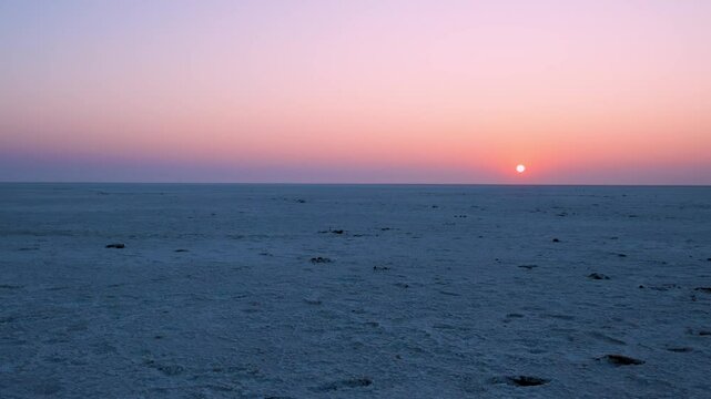 white salt flats desert with sunset dramatic orange sunrise sky at dawn video is taken at dhordo kutch white rann gujrat india.