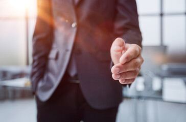 Businessman manager stretching out hand for handshake to partner in office closeup. Team work concept