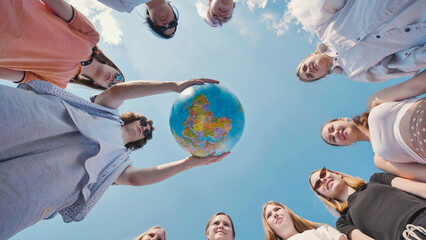 Students holding a globe in a circle, showcasing global awareness, environmental responsibility,...