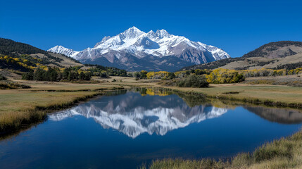 Majestic snow-capped mountain reflected in autumnal lake
