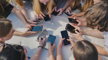 Young friends gather in a circle, using their smartphones to stay connected in the digital age