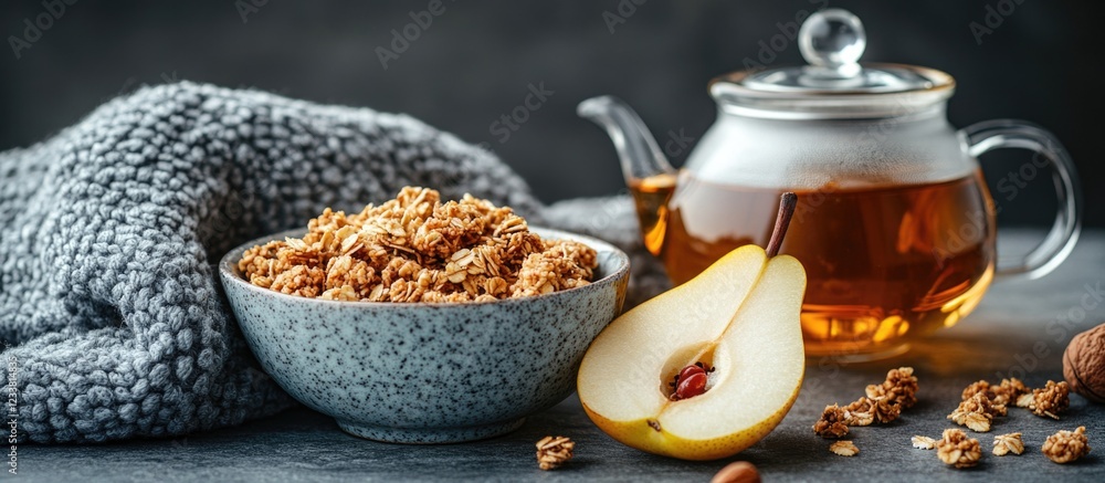Poster healthy breakfast setup with oatmeal in bowl, half pear, and tea pot on gray background with soft te