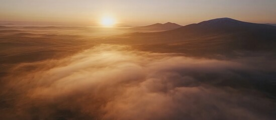 Mist Covered Mountains at Sunrise with Golden Light and Copy Space for Text