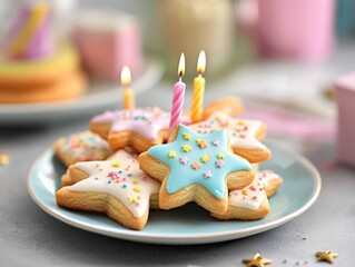 Star-shaped cookies decorated with pastel icing and sprinkles, placed on a plate, accompanied by colorful birthday candles, creating a festive atmosphere.