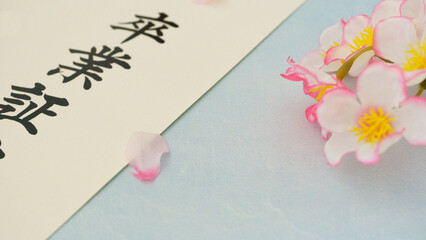 春の訪れを告げる、卒業証書と桜の花びら