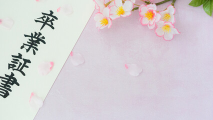 春の訪れを告げる、卒業証書と桜の花びらと卒業証筒