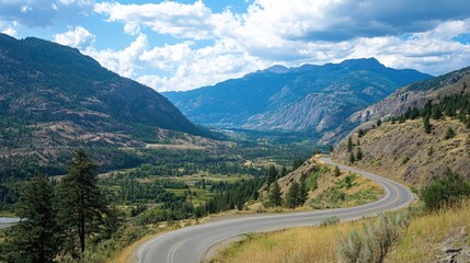 Naklejka premium Scenic Winding Road Through Lush Mountain Landscape Under Blue Sky and Fluffy Clouds