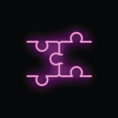 Neon sign in the shape of puzzle pieces is glowing on a black background