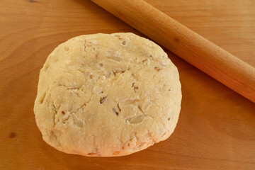 Scone dough kneaded on a wooden work surface.