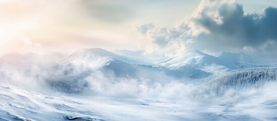 Obraz premium Snowy mountain landscape with clouds and mist during winter sunrise showcasing vastness and tranquility with Copy Space