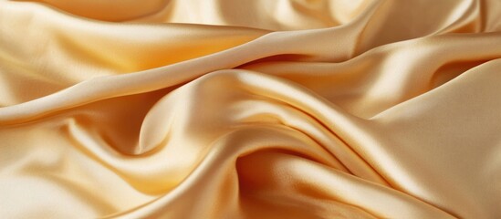 Fototapeta premium Silk fabric texture in soft golden hue with gentle folds and waves ideal for background design and textiles Copy Space