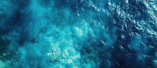 Obraz premium Aerial view of clear turquoise ocean water with coral reef visible beneath the surface Copy Space