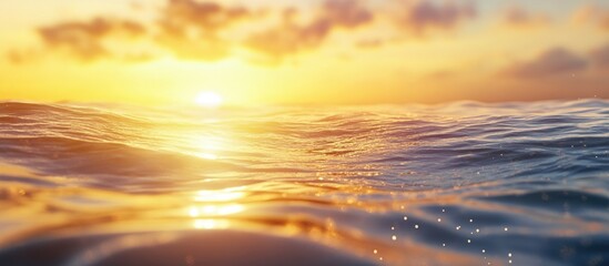 Sunset over tranquil ocean waves reflecting golden light with vivid clouds in the sky and glimmering water droplets Copy Space