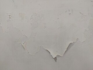 The wall surface shows signs of damage with peeling in an irregular pattern.