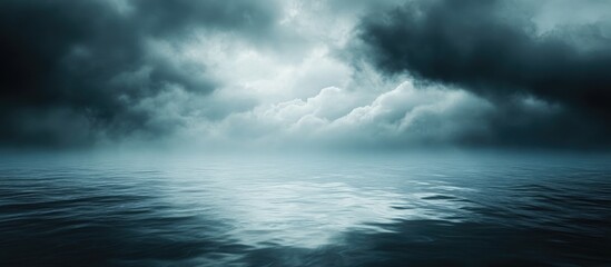 Obraz premium Dark moody seascape with tranquil water surface under dramatic cloudy sky Copy Space