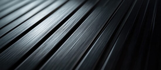Close-up of black metal surface with parallel lines and textured pattern in low light
