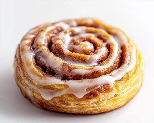 Fototapeta premium Macro shot of a cinnamon roll with glossy icing and layered details on a white background.
