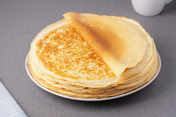 Stack of traditional russian pancakes blini on gray background. Homemade russian thin pancakes blini. Russian food, russian kitchen