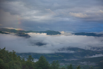 Evening Fog and Rainbow in a Mountain Valley