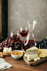 Red wine in a decanter and different types of cheese