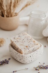 Fototapeta premium A terrazzo soap dish showcases a handcrafted soap bar, surrounded by rolled towels and dried lavender, creating a serene and inviting atmosphere perfect for relaxation and wellness