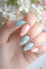 Pastel-colored nails feature tiny floral designs and are perfectly complemented by delicate fresh flowers. The soft daylight enhances the elegant look, creating a serene atmosphere