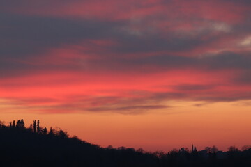 tramonto in inverno con alberi e cielo rosso e nuvole