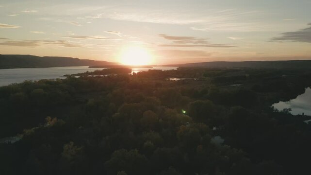 Sunset over confluence of two rivers surrounded by lush green forest